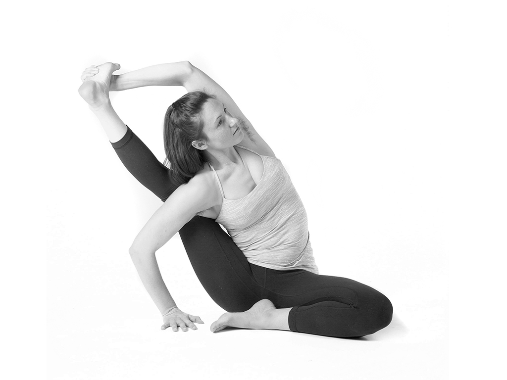 Student practicing restorative child pose over a bolster