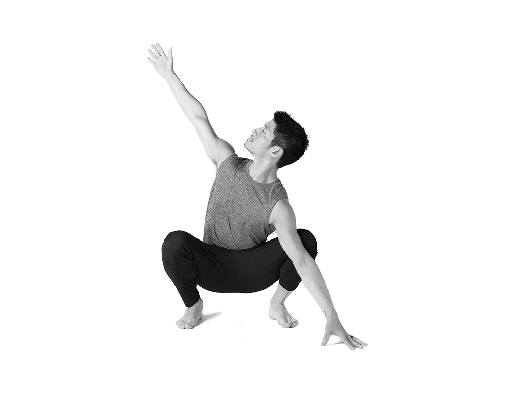 Student practicing restorative child pose over a bolster