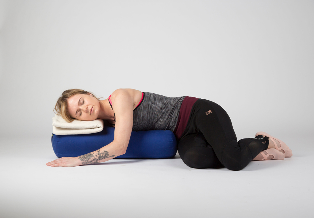 Yoga student relaxing in a restorative twist