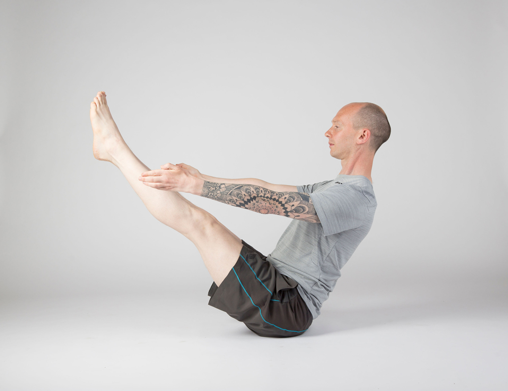 A group of ashtanga yoga students seated in a deep twist