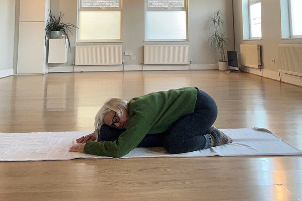 Yoga teacher demonstrating a somatic yoga movement