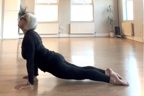 Yoga student relaxing in a restorative twist supported on a bolster